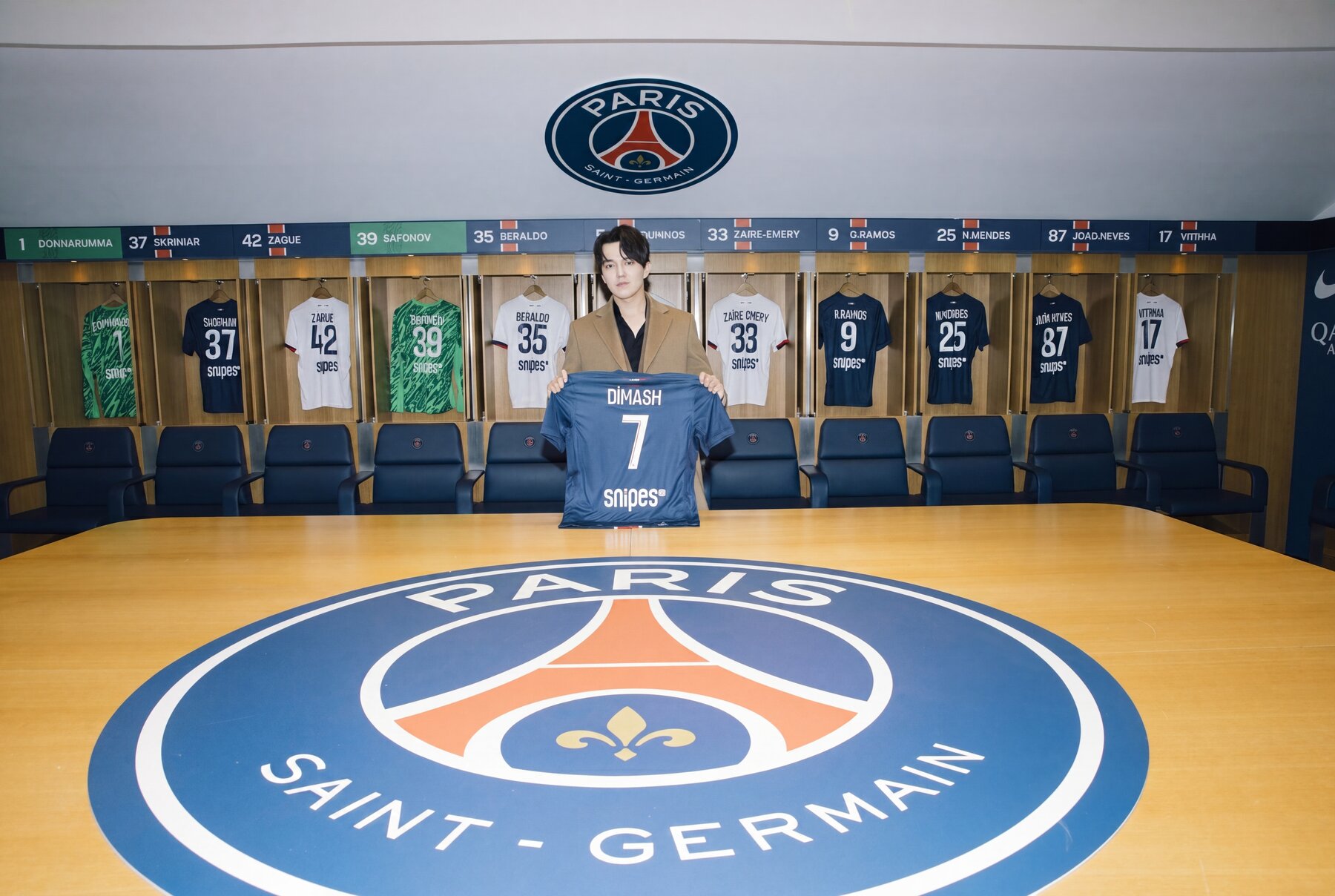 Dimash in the PSG locker room holding a personalised #7 DIMASH jersey